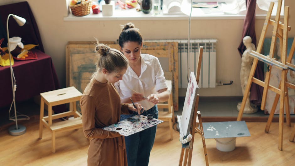 Two women engaging in painting inside a bright art studio filled with creative tools.